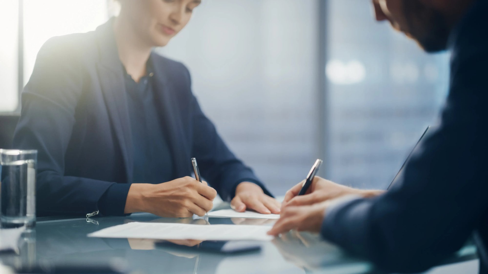 Two people signing papers